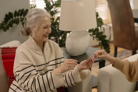 Femme souriante tenant des cartes lors d’un échange autour de la voyance.