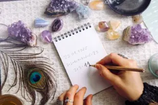 Carnet entouré de cristaux et d’objets associés à la voyance