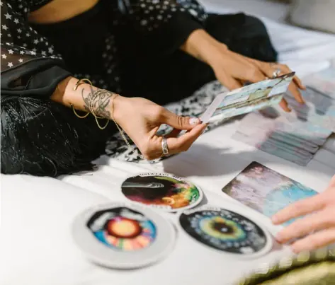 Personne comparant plusieurs jeux de cartes divinatoires lors d’un tirage